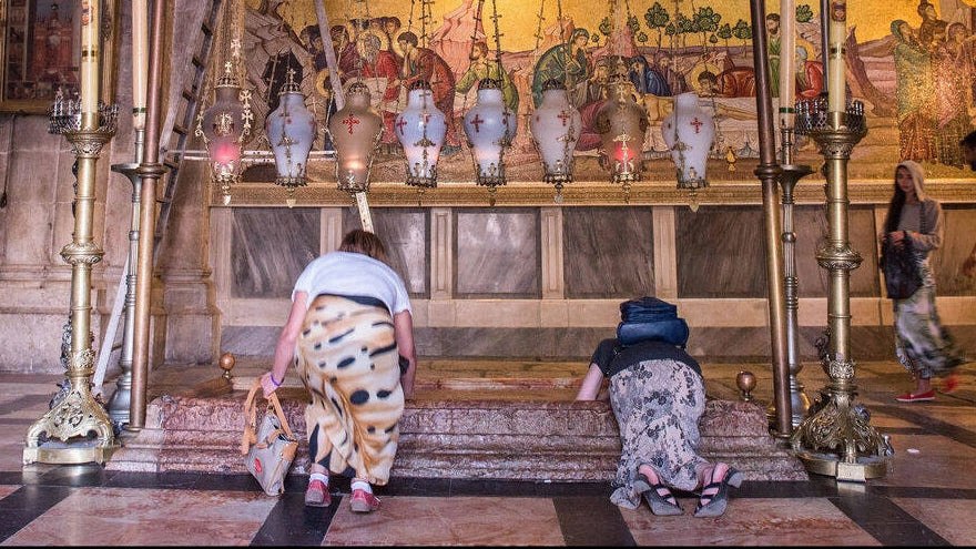 People praying in a religious setting with ornate decorations and religious iconography.