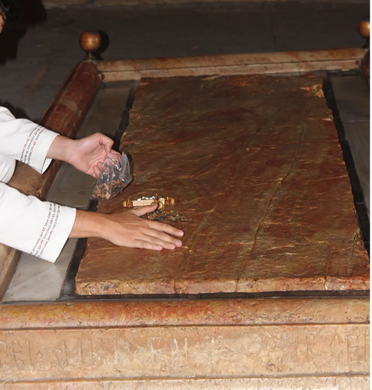 Person touching a Stone of Anointing with cross and some gifts from ChristianCrafts.shop