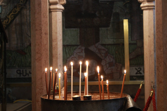 Candle holder with lit candles in a dimly church in Bethlehem. ChristianCrafts.shop