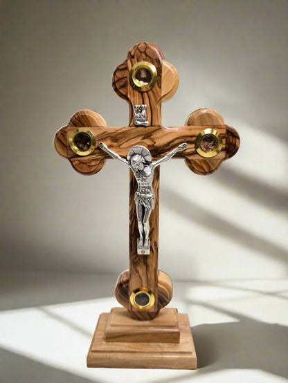 Wooden cross with a figure of Jesus on a gray background