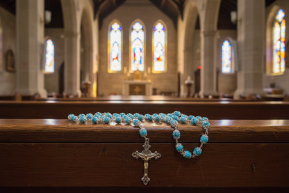 Blue rosary on a wooden surface